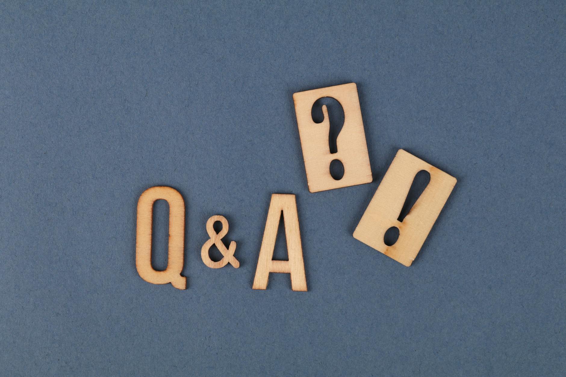 wooden letters and wooden punctuation marks on gray surface